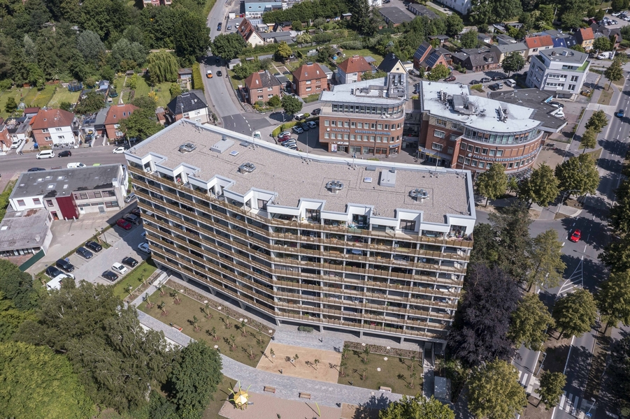Das sanierte Hochhaus Sterntalerweg 1-3 aus der Luft. Man sieht die Rückseite mit dem gold-glänzenden Balkonbrüstungen, dahinter das Gesundheitszentrum.