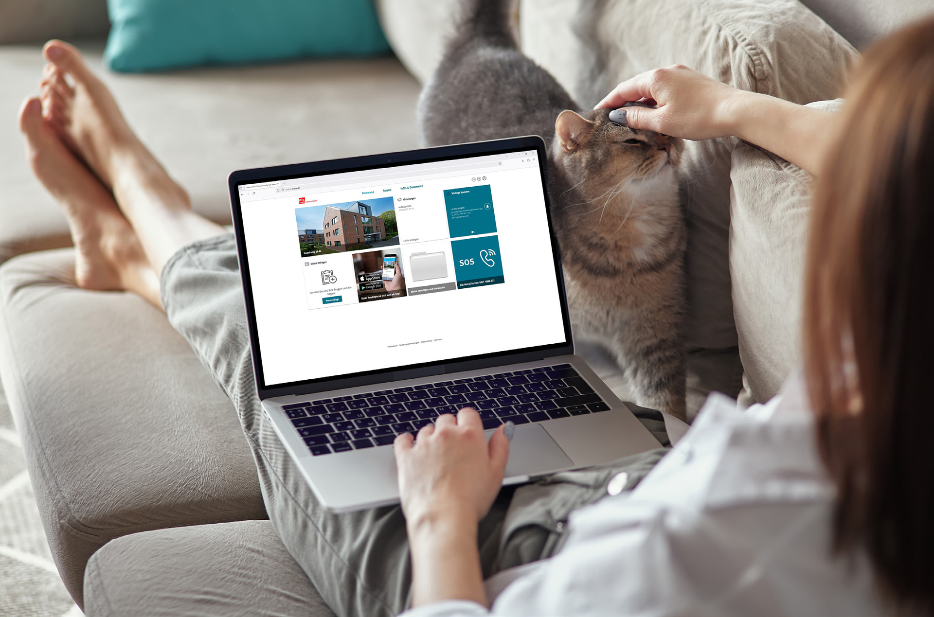 Person nutzt Laptop mit TRAVE-Service-Portal auf dem Sofa neben einer Katze