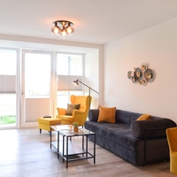 das gemütliche Sofa, der Couchtisch und ein Ohrensessel mit Fußhocker