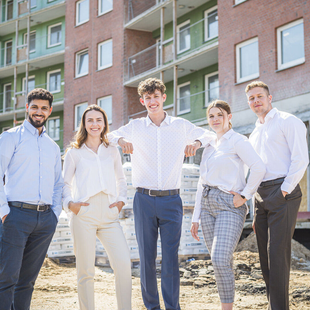 Die TRAVE bildet aus Fünf TRAVE-Azubis aus verschiedenen Ausbildungsjahrgängen auf einer Baustelle.