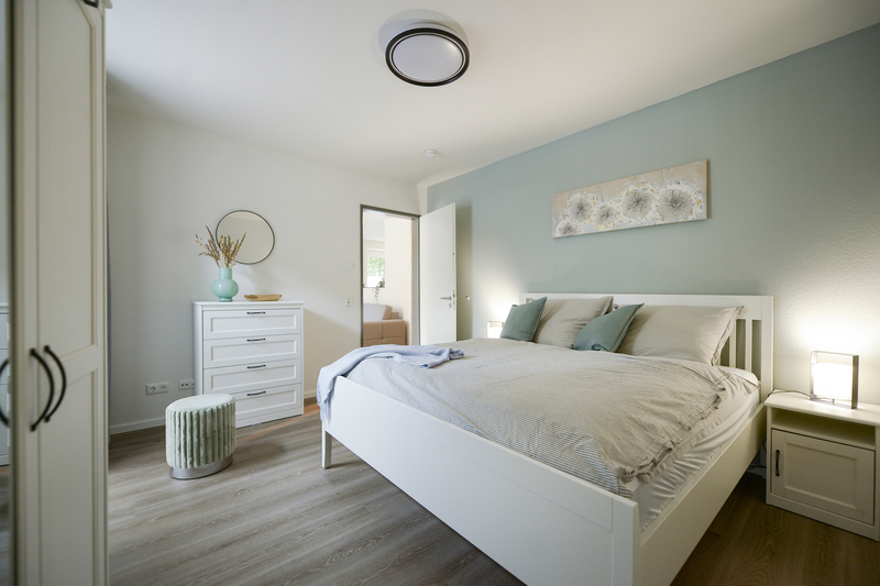 Schlafzimmer der Gästewohnung mit Doppelbett und Kommode.